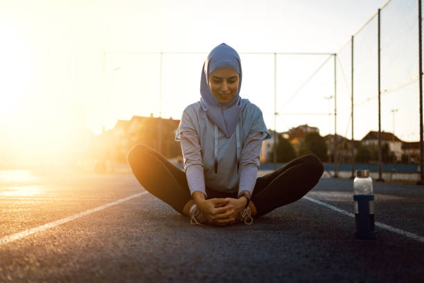 istock After intense training, Muslim female athlete stretching her legs 1349232186