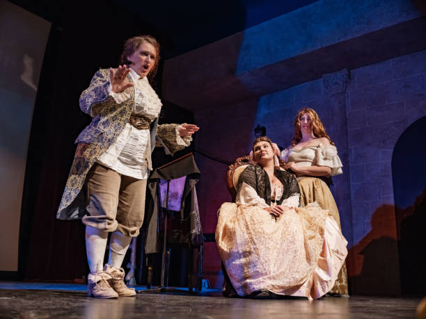 drei schauspielerinnen in historischen kostümen auf der theaterbühne - bühnentheater stock-fotos und bilder