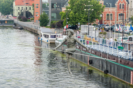 Bydgoszcz, Poland - July 25, 2021: Statue Crossing the River by Jerzy Kedziora. Sculpture over Brda river in Bydgoszcz.