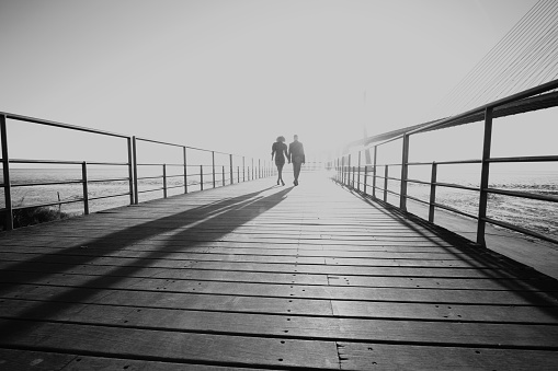 Silhouette couple walking to the sunset