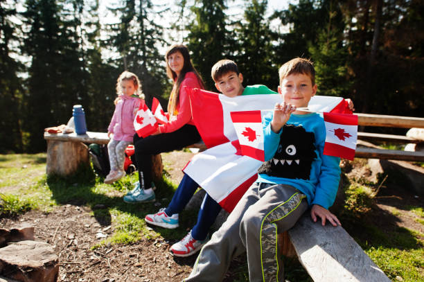 feliz día de canadá. familia de madre con tres hijos celebran una gran celebración de la bandera canadiense en las montañas. - toronto canada flag montreal fotografías e imágenes de stock