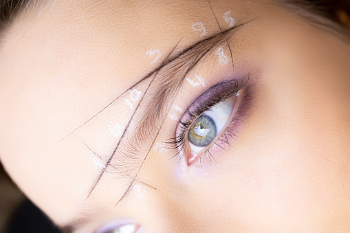 close-up of the eyes of the model on the eyebrows which is drawn marking the architecture of the eyebrows