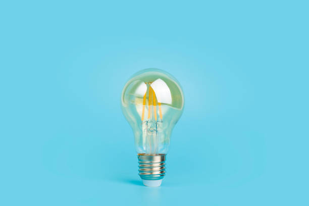 istock Knowledge and idea concept. Light bulb with light on a blank blue background. Brain, wisdom, knowledge and energy conservation is a creative idea. 1349244419