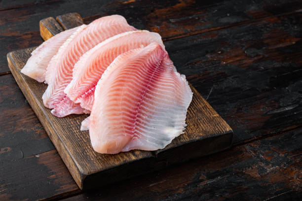 istock Tilapia fish skinless meat, on old wooden table 1349245353