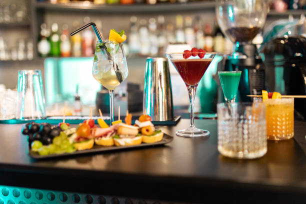 cocktails and appetizers on bar counter - shot glass glass alcohol color image imagens e fotografias de stock