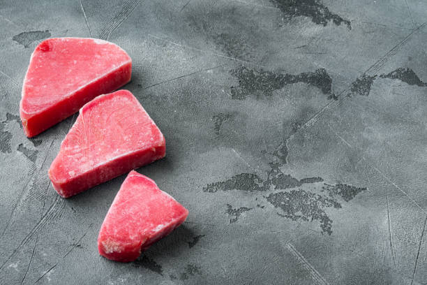 istock Frozen tuna fish steaks, on gray stone background , with copyspace  and space for text 1349245532