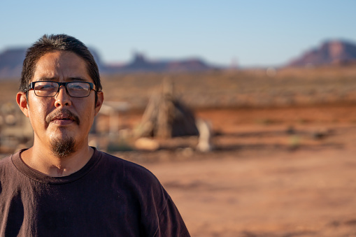 Navajo Young Native American Man Landscape Portrait in front of Monument Valley Arizona with Tracheotomy Scar from Being on a Ventilator with Coronavirus Covid-19