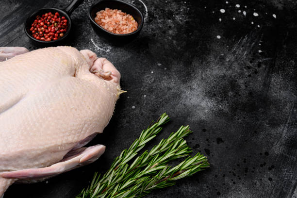 istock Gressingham duck ready to cook with herbs, on black dark stone table background, with copy space for text 1349246734