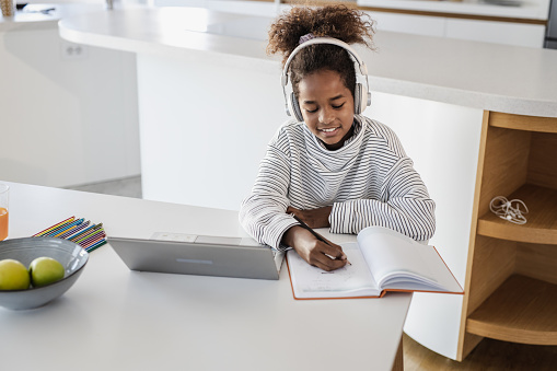 High angle view of a young girl at home doing homework