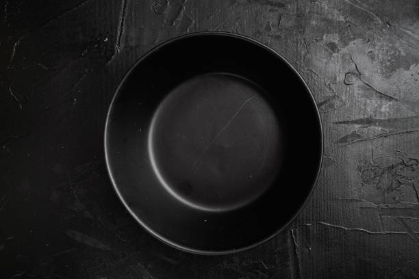 istock Black bowl, with copy space for text or food, with copy space for text or food, top view flat lay , on black dark stone table background 1349248527