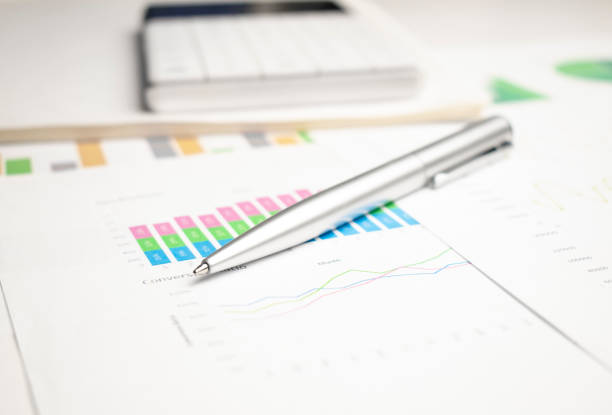 istock closeup blue graph and chart reports and pen on office table, financial and business concept 1349253282