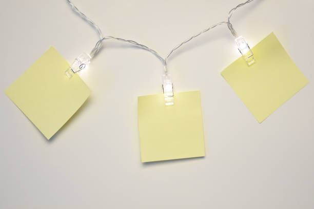 istock Blank note papers hanging on Christmas lights with white background 1349255541