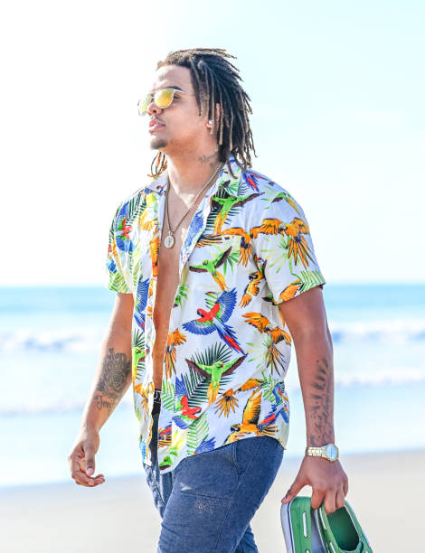 istock Handsome happy mixed race young guy walking barefoot on an idyllic beach in sunglasses 1349256872