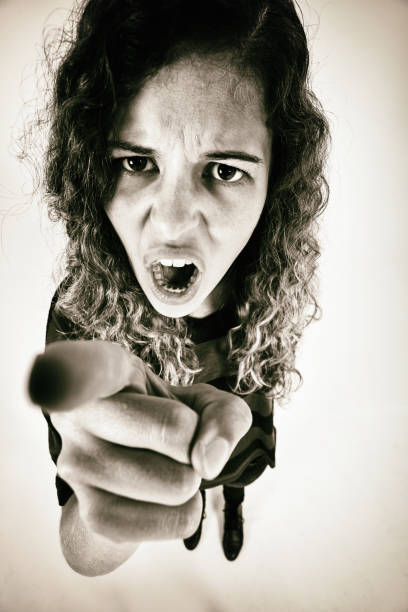 istock Beautiful young woman, very angry, points accusingly at the camera as if fighting, arguing or blaming 1349257089