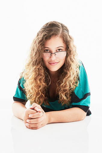 Lovely young woman with long curly brown hair looks relaxed and confident.