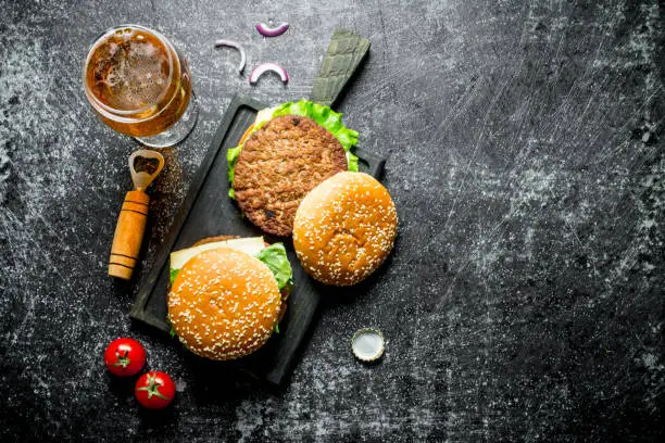 Photo of burgers and beer in isolated dark background