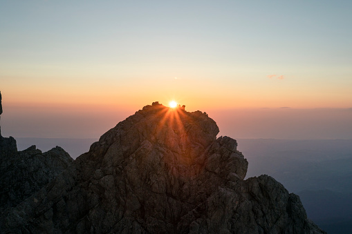 Sunrise over a mountain peak with spreading sunrays in Isola del Gran Sasso d'Italia, Abruzzo, Italy