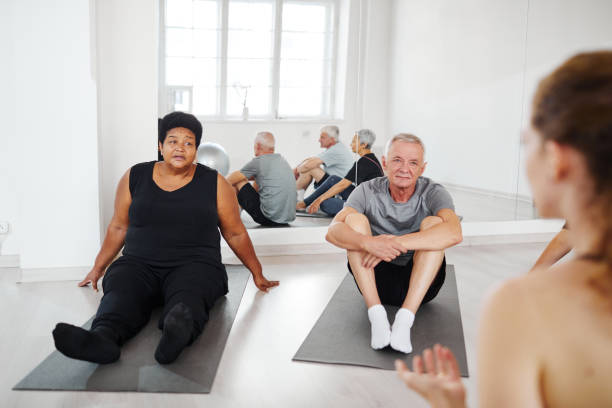 istock Senior people practicing yoga in the studio 1349259735