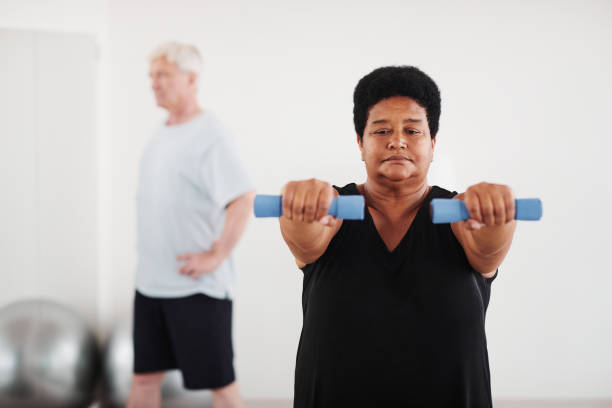 istock Woman exercising with dumbbells in studio 1349259788