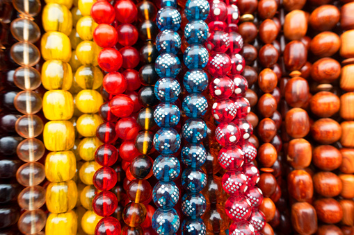 Many kind of Rosaries in different colors and sizes.Various types of prayer beads. Strings of colorful beads hung at outdoor crafts market.