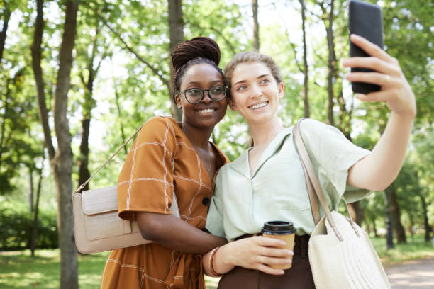 istock Two Smiling Young Women Taking Selfie in Park 1349260482