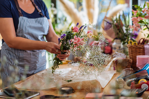 Unrecognizable woman florist working in her flower shop
