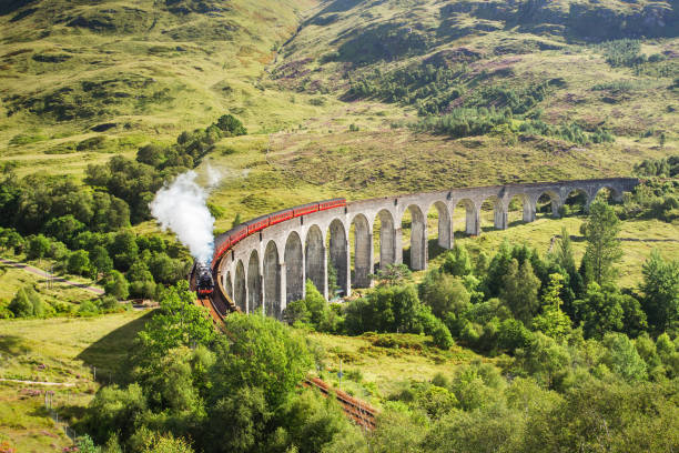 Jacobite steam train on Glenfinnan Viaduct approaching, Highlands, Scotland, United Kingdom Jacobite steam train on Glenfinnan Viaduct approaching, Highlands, Scotland, United Kingdom. lochaber stock pictures, royalty-free photos & images