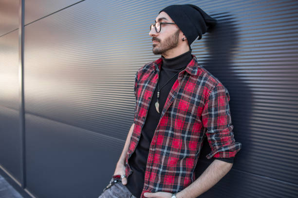 istock A hipster young man leaning against a gray wall 1349262010