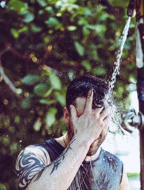 istock Handsome fit young guy showers outdoors after trip to the beach 1349266592