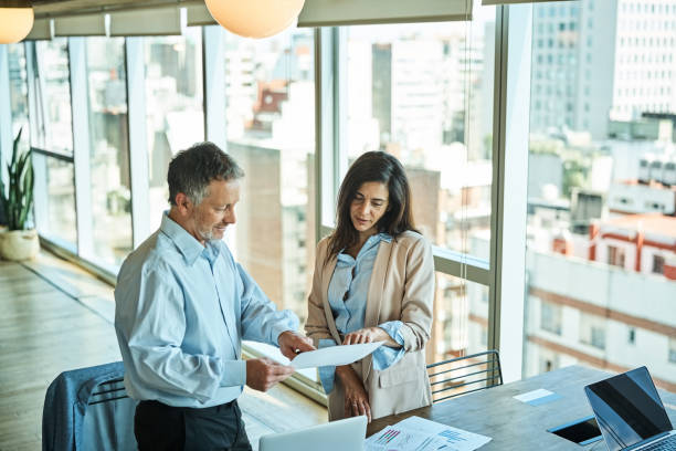 istock Business professionals discussing over reports in office 1349268430