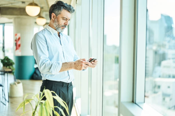 istock Mature businessman using mobile phone in office 1349268968