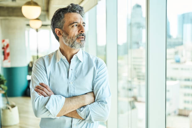 istock Thoughtful businessman looking through office window 1349268969