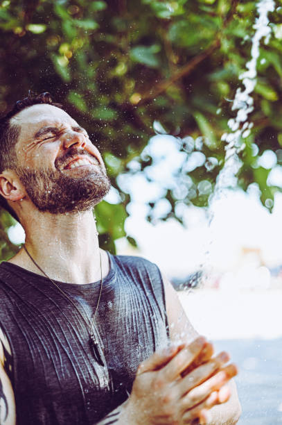 istock Handsome fit young guy showers outdoors after trip to the beach 1349269583