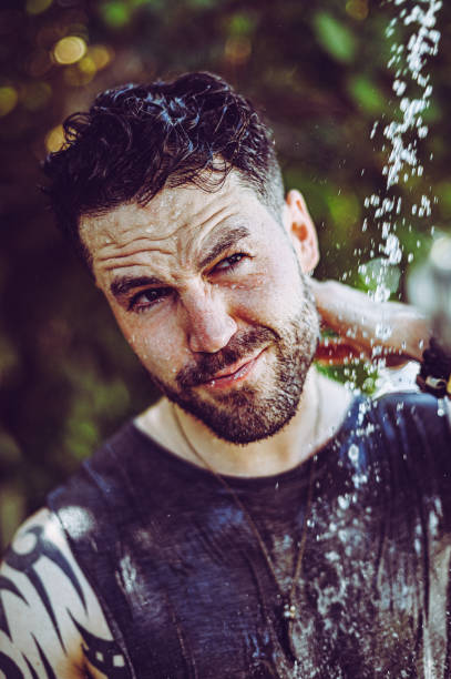 istock Handsome fit young guy showers outdoors after trip to the beach 1349269587