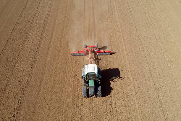 istock Tractor cultivating field, aerial view 1349279063