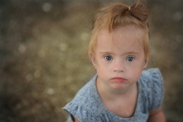 istock beautiful girl with Down syndrome on the beach 1349280109