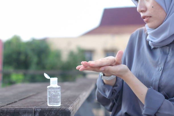 istock young women using hand sanitizer sitting at the park 1349290464