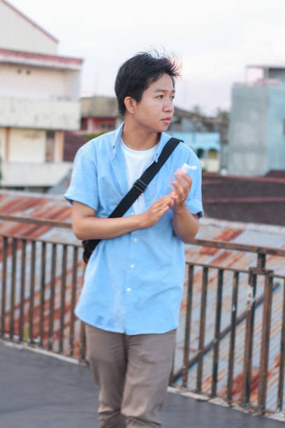 istock young men using hand sanitizer at outdoor city park 1349290467