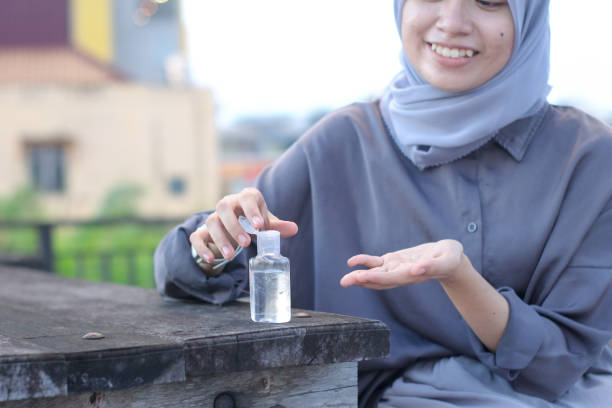 istock young women using hand sanitizer sitting at the park 1349292724