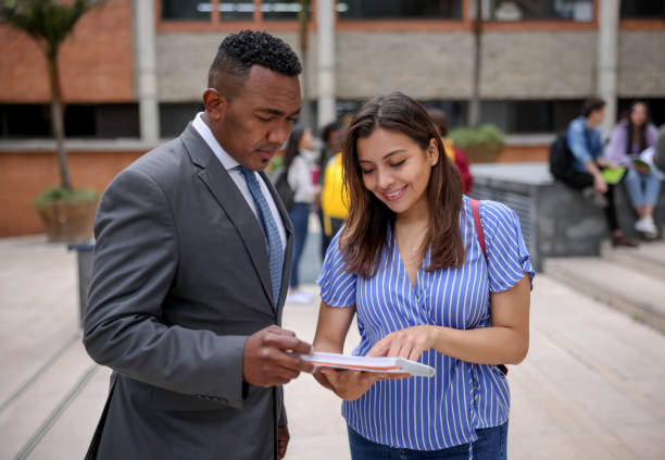 istock College student talking to her teacher at the university campus 1349297983