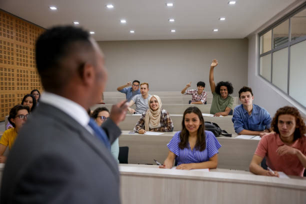 授業中に先生に質問する生徒 - lecture hall college student university multi ethnic group ストックフォトと画像