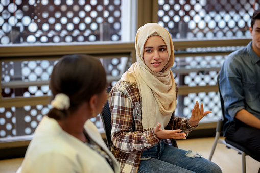 Estudiantes universitarios musulmanes hablando con un grupo en consejería photo