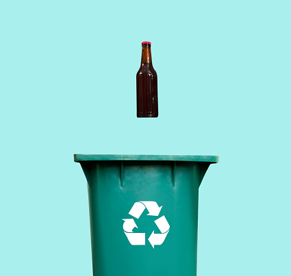Recycling glass bottles minimalistic image. Glass bottle hovering over recycle bin