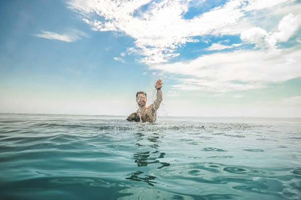 istock Man splashing water in idyllic blue ocean 1349298787