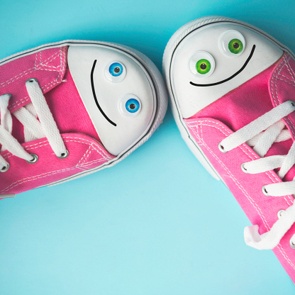 Pink Canvas Shoes with Happy Faces on Blue Background