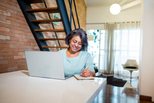 istock A mature woman using her laptop at home. 1349300699