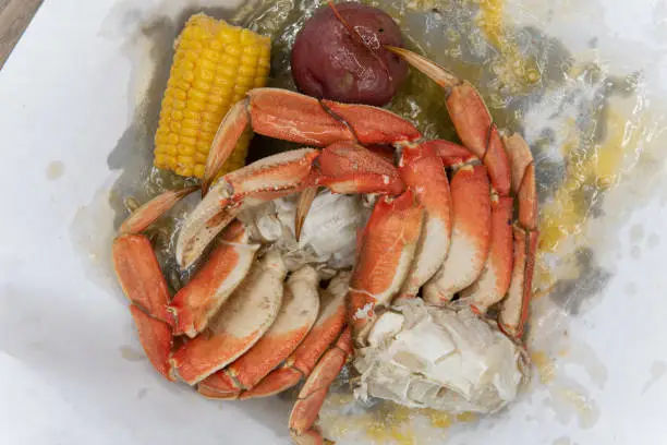 Overhead view of boiled pot of dungeness crab legs ready for the delicious task of breaking and eating the meat inside the shell.