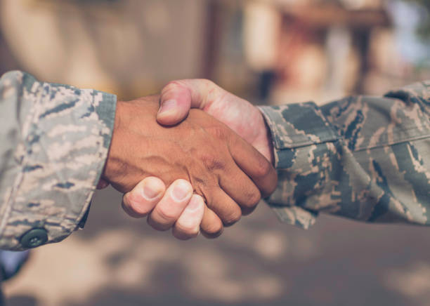 istock Two Male Soldiers in Military Uniform Shaking Hands 1349302481
