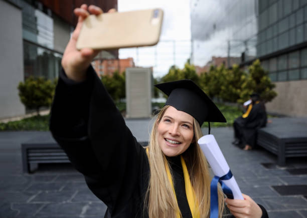 istock Happy graduate student taking a selfie with her diploma on her graduation day 1349302548
