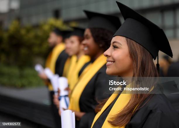 Happy Group Of Graduate Students In A Row Holding Their Diplomas Stock Photo - Download Image Now